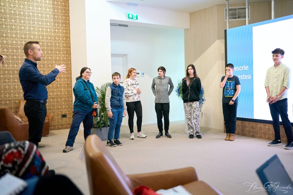 Curs de vorbit în public cu adolescenți și trainer într-o sală modernă, participanții sunt implicați într-un exercițiu.